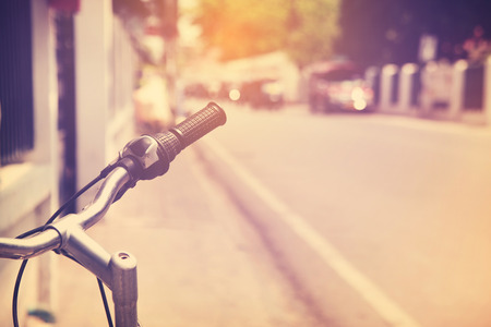 Detail of a Vintage Bicycle Handlebar Resting in the city Street (retro color toned image)の写真素材