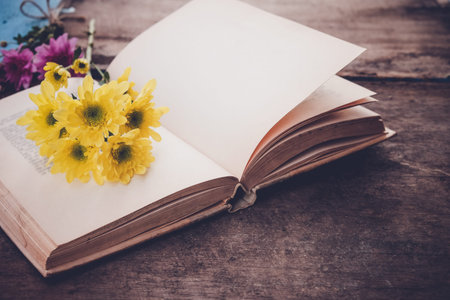 Vintage novel books with bouquet of flowers on old wood background - concept of nostalgic and...
