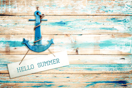 Vintage Hello summer sign hanging with anchor on old wooden blue paint background. vintage wood texture from beach in summer.の写真素材