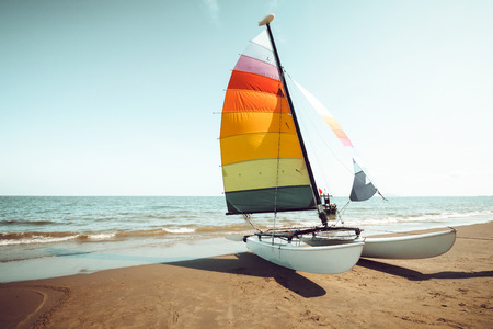 Vintage colorful sailboat on tropical beach in summer. retro color tone effectの写真素材