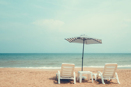 Couple beach chair on tropical beach. vintage color tone effectの写真素材