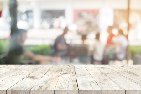 Empty clear white wood table for product placement or montage, perspective style. blurred people in coffee shop (cafe) background.の写真素材