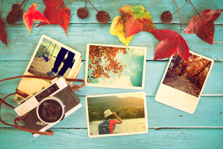Photo album in remembrance and nostalgia in autumn (fall season) on wood table. instant photo of...