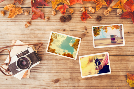 Photo album in remembrance and nostalgia in autumn (fall season) on wood table. instant photo of retro camera - vintage and retro styleの写真素材
