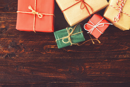 Christmas background with decorations and handmade gift boxes on old wooden board with copy space....