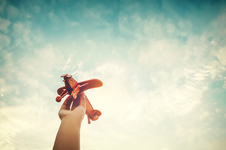 Childhood inspiration - Hands of children holding a toy plane and have dreams wants to be a pilot - Vintage filter effectの写真素材