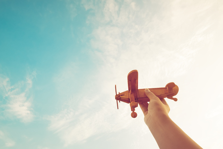 Childhood inspiration - Hands of children holding a toy plane and have dreams wants to be a pilot - Vintage filter effectの写真素材