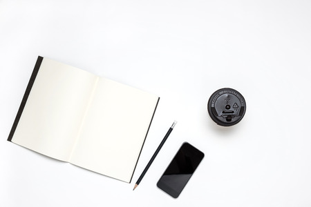 Business workspace desk with notebook, smartphone, pencil and hot coffee cup on white background. Creative Flat layout and top view composition with border and copy space design.の写真素材