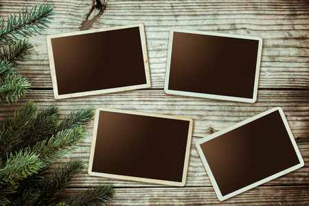 Christmas background - Blank photo frame paper with fir tree decorating rustic elements on vintage wood table. Creative Flat layout and top view composition with border and copy space design.の写真素材
