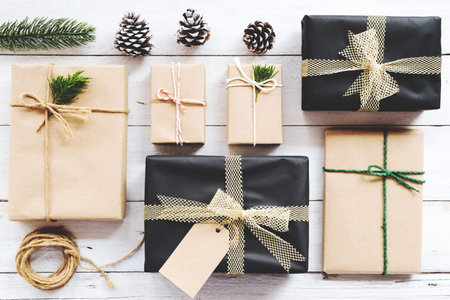 Christmas background with handmade present gift boxes and rustic decoration on white wooden board....