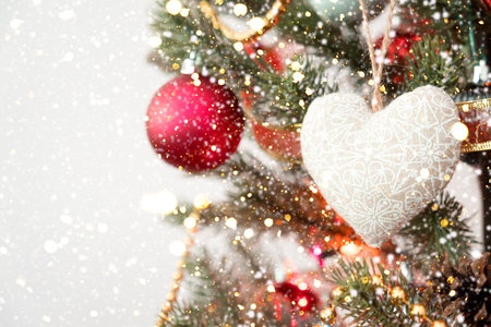 Close-up of Christmas tree with ornament, decoration and light bokeh with snowfall on winter backgroundの写真素材