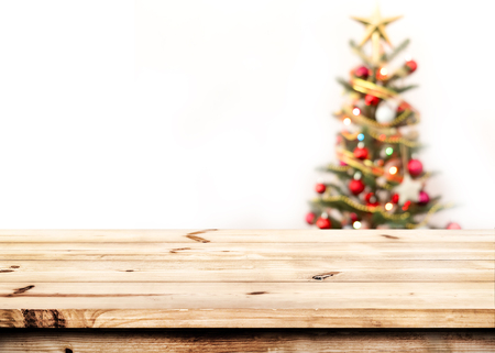 Christmas and New year background with empty  wooden deck table over christmas tree and blurred light bokeh. Empty display for product montage. Xmas background.の写真素材