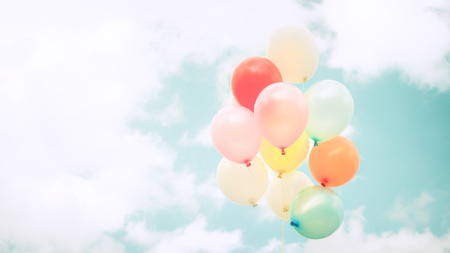 Vintage multicolor balloons with done with a retro filter effect on blue sky.の写真素材