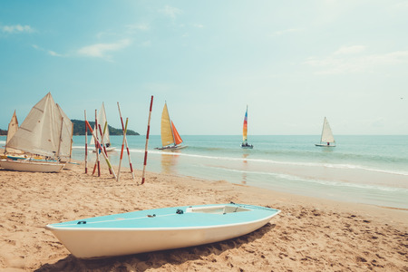 Sailboat on sand tropical beach in summer. vintage retro color tone effectの写真素材
