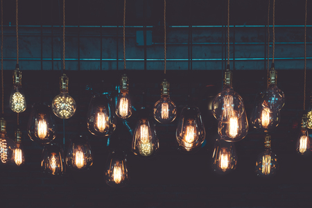 Beautiful vintage luxury light lamp hanging decor glowing in dark. Retro filter effect style.の写真素材