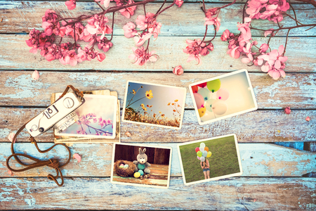 Retro camera and paper photo album on wood table with flowers border design - concept of remembrance and nostalgia holiday in spring. vintage styleの写真素材