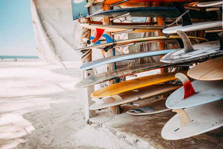 Set of different colorful surf boards in a stack available for rent on the beach. vintage color tone effect.の写真素材