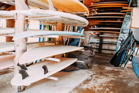 Set of different colorful surf boards in a stack available for rent on the beach.の写真素材