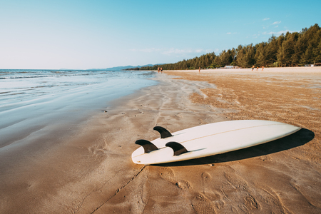Surfboard on sand tropical beach with seascape calm sea and sky background. summer vacation background and water sport concept. vintage color tone effect.の写真素材