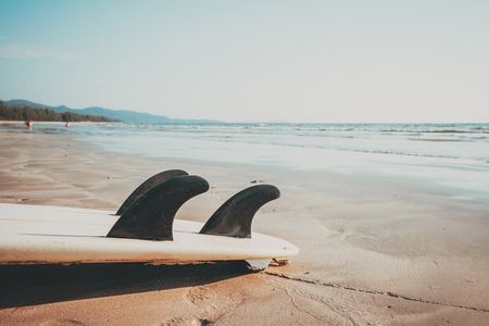 Surfboard on sand tropical beach with seascape calm sea and sky background. summer vacation background and water sport concept. vintage color tone effect.の写真素材