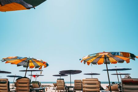 Sunbeds on tropical beach with calm sky. sea view and sand beach, summer background. vintage color tone effectの写真素材
