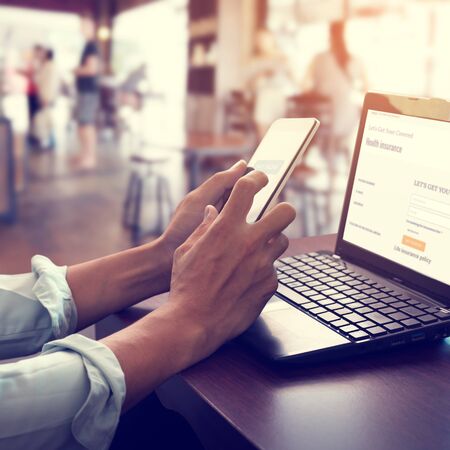 Concept online payment mobile technology. Hand of men using smartphone. Touch the pay button of mobile banking application to make health insurance.の写真素材