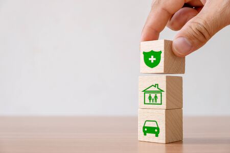 Insurance and investment concept of health, life, accident and travel.
Hand picked wooden block with insurance sign and symbol of house, family, carの写真素材