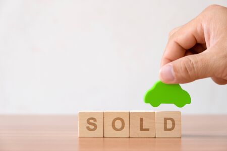 Vehicle, transportation investment and car mortgage financial concept. Hands holding wooden car and wood cube block with RENT word.の写真素材
