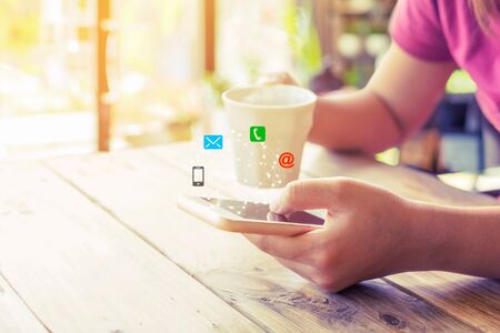 Business connection contact us and call center customer service concept. Woman hand using smartphone with Icon mobile phone, email envelope, telephone and e-mail addressの写真素材