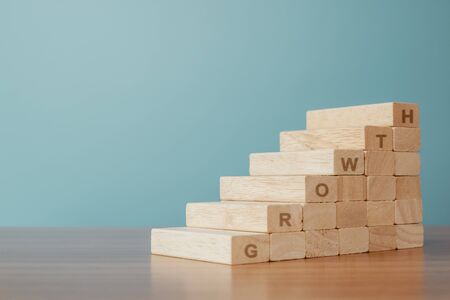 Business concept of ladder career path and growth success process. Wood cube block stacking as step stair.の写真素材