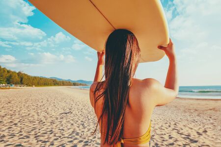 Women surfer with surfboard on beachの写真素材