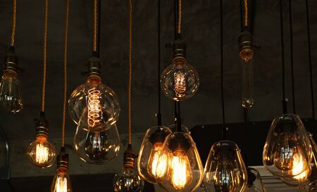 House interior of loft and rustic style. Beautiful vintage luxury light bulb hanging decor glowing in dark. Retro filter effect style. Blend of history and modern.の写真素材