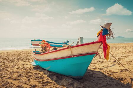 Vintage fishing boat on the beach at sunset time with sky and the sea on the background.の写真素材