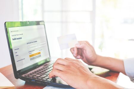 Concept online payment with cradit card. Hand of men using laptop for to payment make online health insurance.の写真素材