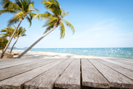 Top of wood table with seascape and palm tree, blur bokeh light of calm sea and sky at tropical...