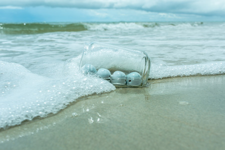 Ceramic whales in bottle on the beach.の写真素材