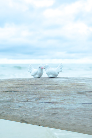 White ceramic pigeons on dead tree.の写真素材