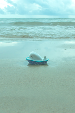Ceramic whale in bathtub toy on the beach.の写真素材
