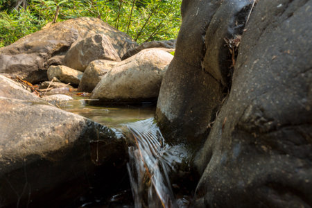 Small waterfall with natural light in deep forest.