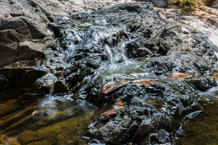 Small waterfall with natural light in deep forest.の写真素材