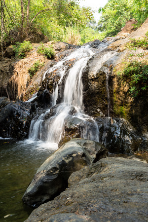 Small waterfall with natural light in deep forest.の写真素材