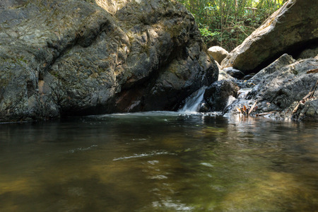 Small waterfall with natural light in deep forest.の写真素材