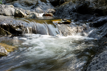 Small waterfall with natural light in deep forest.の写真素材