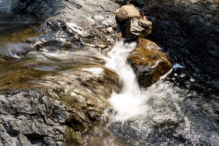 Small waterfall with natural light in deep forest.の写真素材