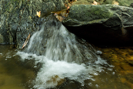 Small waterfall with natural light in deep forest.の写真素材