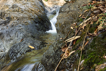 Small waterfall with natural light in deep forest.の写真素材