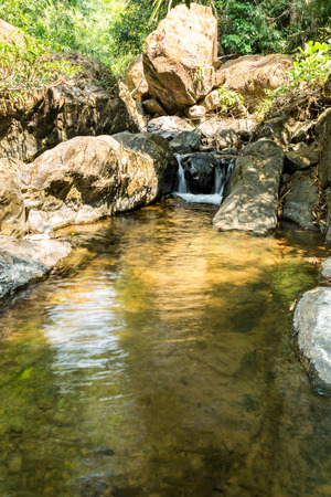 Small waterfall with natural light in deep forest.の写真素材