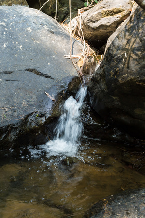 Small waterfall with natural light in deep forest.の写真素材