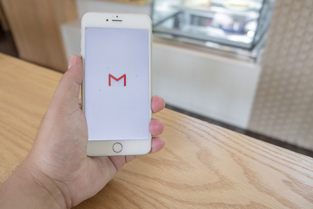 Chiang Mai / Thailand - September 22 2018 :A man sit in cafe holding mobile with gmail screenのeditorial素材