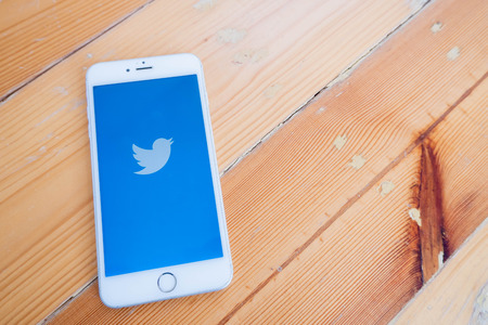 Chiang Mai / Thailand - October 6 2018 :iPhone with twitter screen on wood deskのeditorial素材